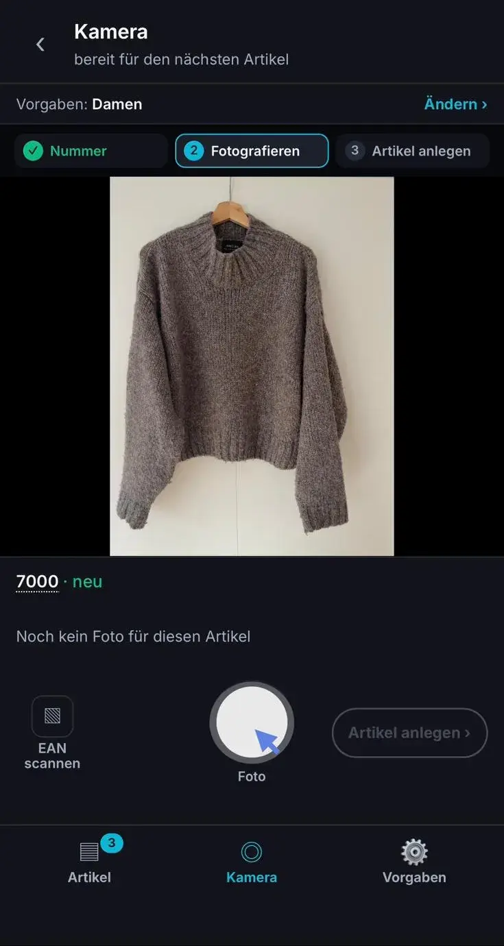 Kamera mit einem Strickpullover auf einem Bügel, Auslöser ist markiert